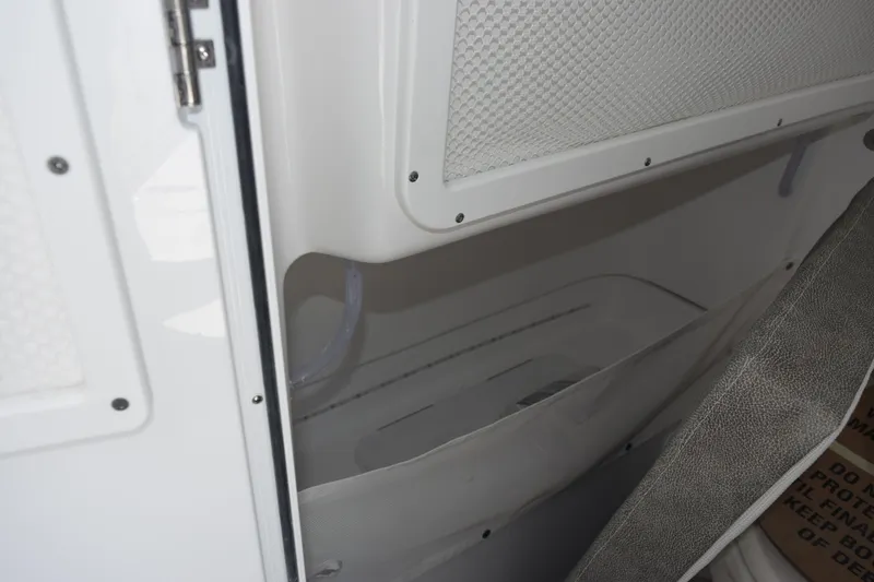 Slide: The Image of Interior storage compartment of 2026 Sea Hunt Gamefish 25 boat, featuring white finish and netting. - 20