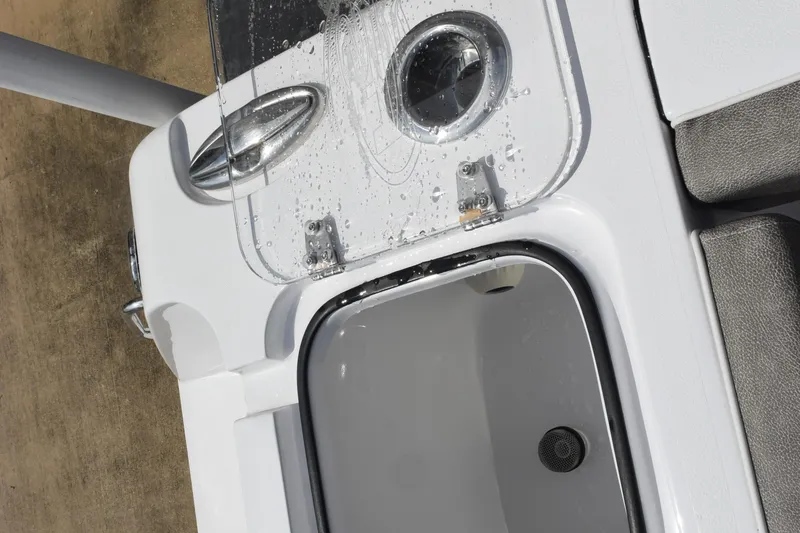 Slide: The Image of Open storage compartment on 2026 Sea Hunt Gamefish 25 boat, featuring a sleek design and water droplets. - 27