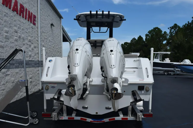 Slide: The Image of 2026 Sea Hunt Gamefish 25 boat with dual outboard motors, parked at a marine dealership. - 4