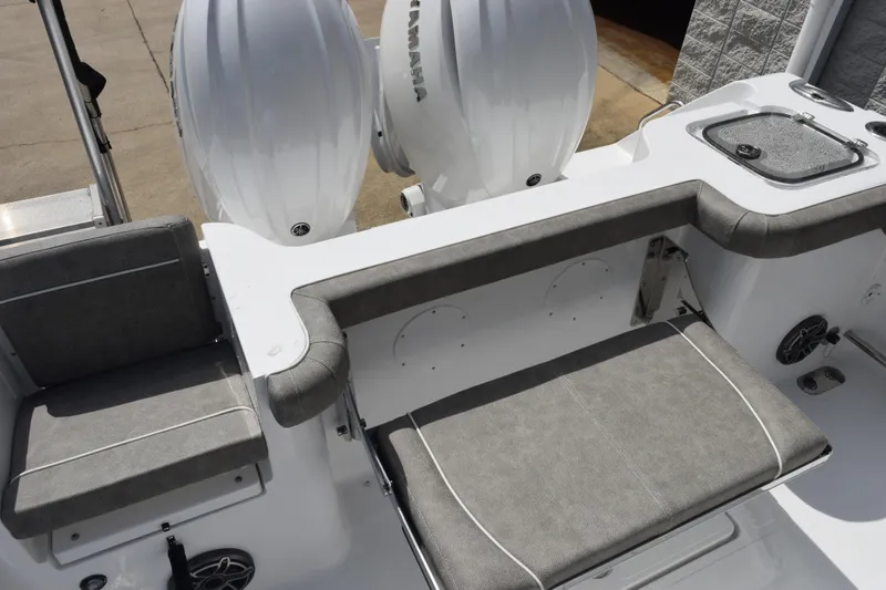 Slide: The Image of 2026 Sea Hunt Gamefish 25 boat interior with cushioned seating and dual outboard engines. - 8