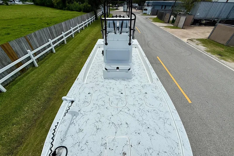 Slide: The Image of 2024 Shallow Sport 25 X3 boat on a road, showcasing deck and console. - 15