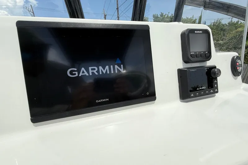 Slide: The Image of 2024 Shallow Sport 25 X3 boat dashboard with Garmin, Suzuki, and JL Audio displays. - 16