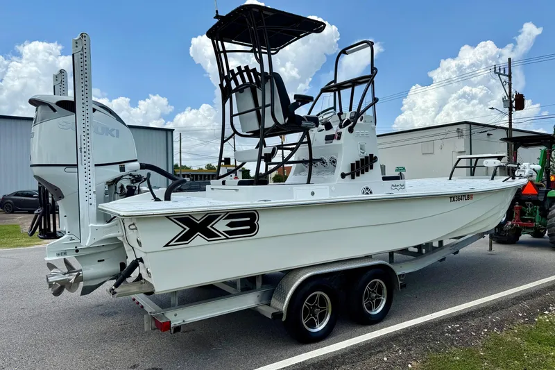 Slide: The Image of 2024 Shallow Sport 25 X3 boat on trailer, featuring Suzuki outboard motor. - 4