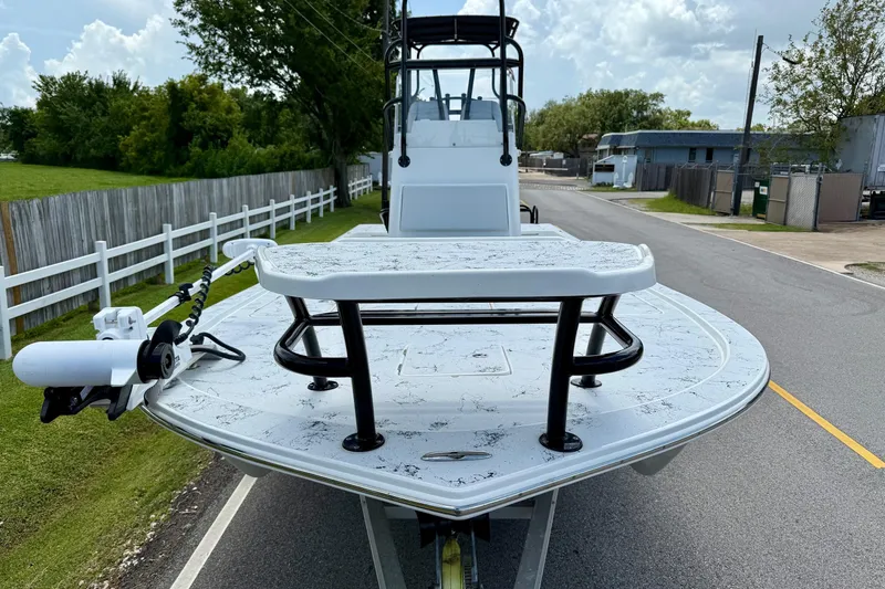 Slide: The Image of 2024 Shallow Sport 25 X3 boat on a road, showcasing its front deck and trolling motor. - 6