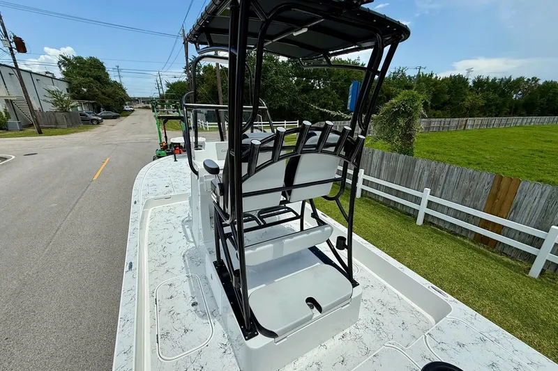 Slide: The Image of 2024 Shallow Sport 25 X3 boat with elevated seating, parked on a street. - 8