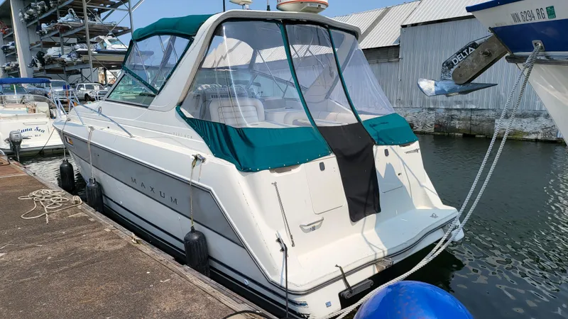 Slide: The Image of 1994 Maxum 3200 SCR boat docked at marina with teal canopy and white hull. - 2