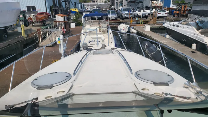 Slide: The Image of 1994 Maxum 3200 SCR boat docked at a marina, surrounded by other vessels. - 26