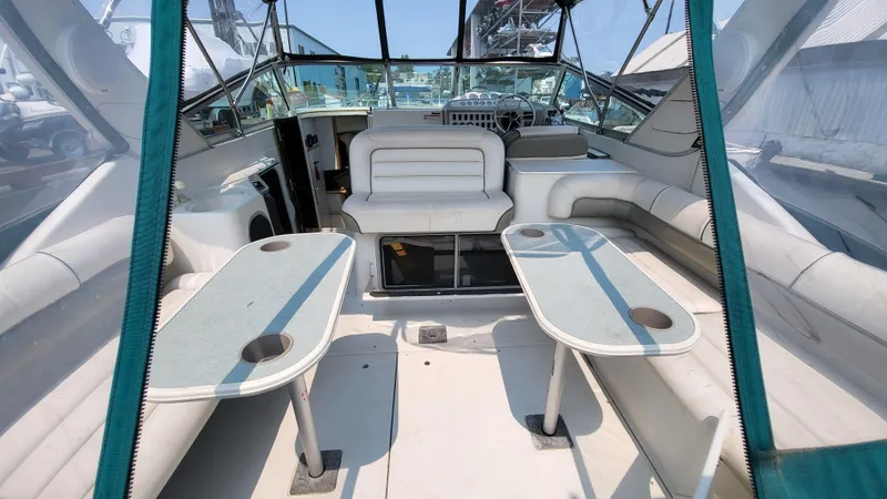 Slide: The Image of 1994 Maxum 3200 SCR boat interior with seating and tables, featuring a spacious cockpit design. - 3