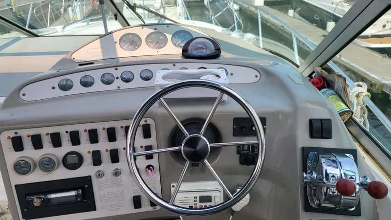 Slide: The Image of 1994 Maxum 3200 SCR boat dashboard with steering wheel and control panel. - 7