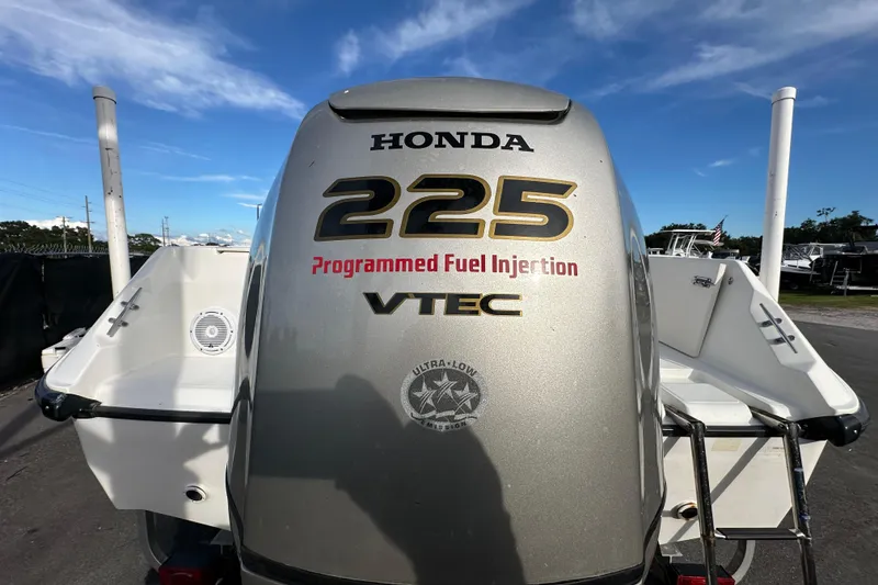 Slide: The Image of Honda 225 VTEC engine on 2002 Boston Whaler 210 Ventura boat, clear sky background. - 11