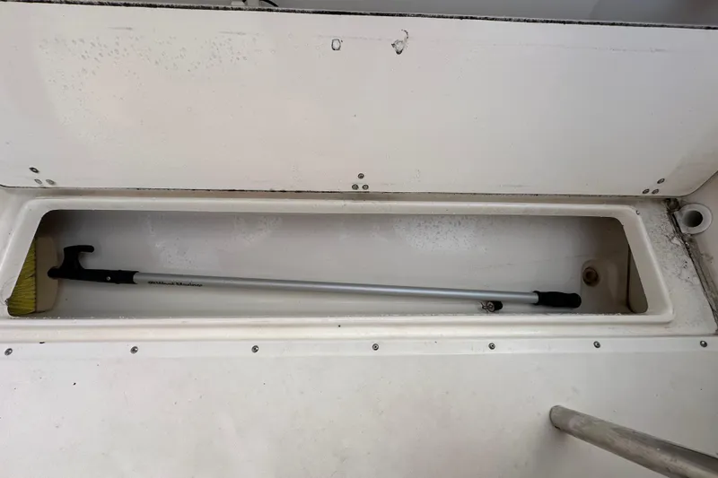 Slide: The Image of Storage compartment of a 2002 Boston Whaler 210 Ventura boat with cleaning brush. - 40