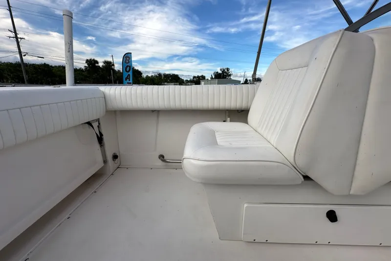 Slide: The Image of 2002 Boston Whaler 210 Ventura boat interior with white seating and clear sky background. - 46