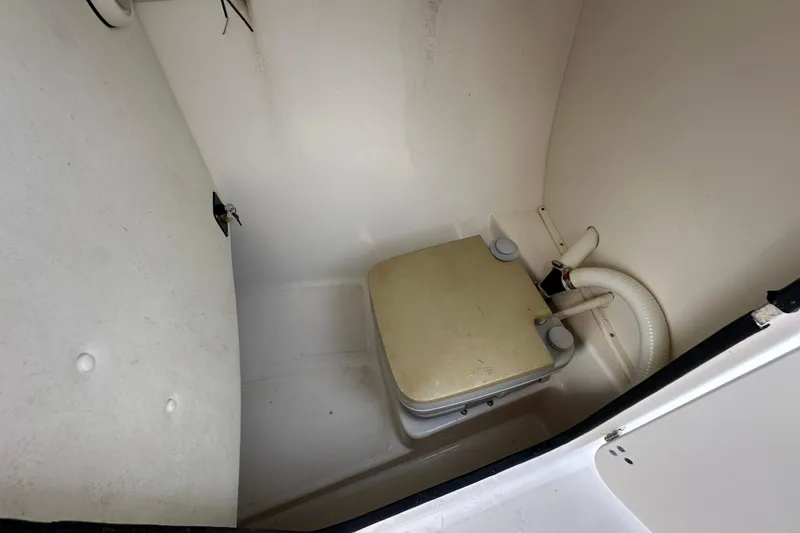 Slide: The Image of 2002 Boston Whaler 210 Ventura boat interior with portable toilet and plumbing. - 64