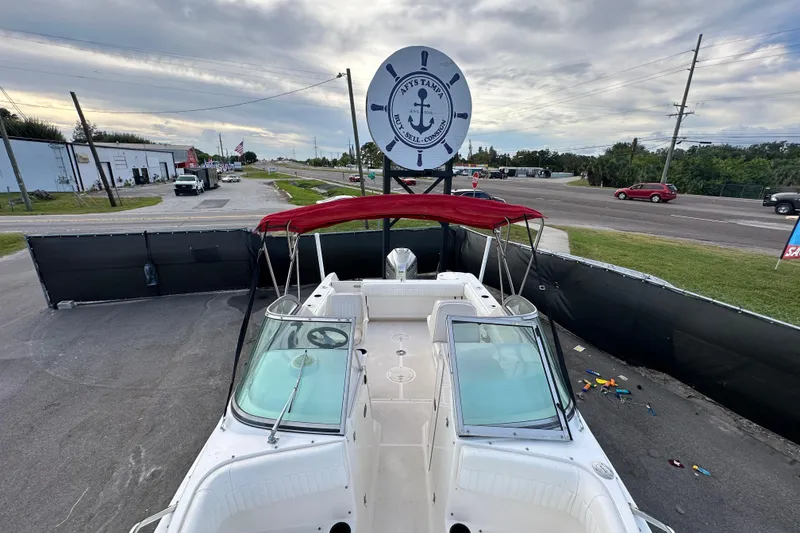 Slide: The Image of 2002 Boston Whaler 210 Ventura boat with red canopy on display at a dealership. - 80