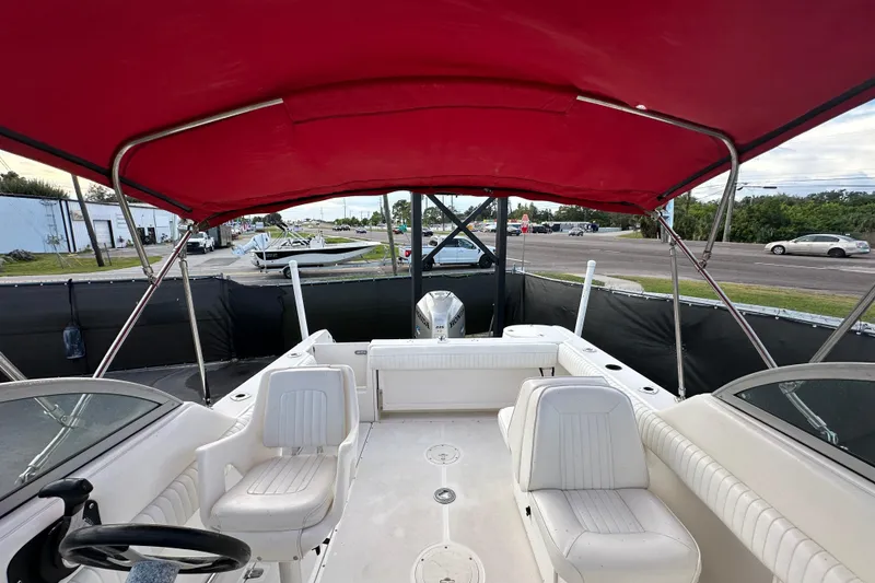Slide: The Image of 2002 Boston Whaler 210 Ventura boat interior with red canopy and white seating. - 87