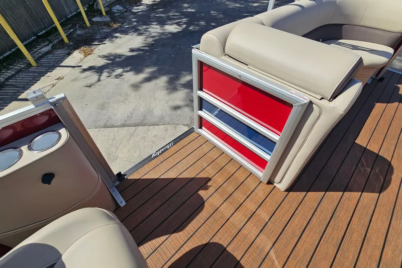 Slide: The Image of 2025 Bentley Pontoons Legacy 243 Swingback interior with beige seating and red accents. - 11