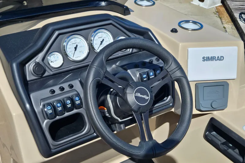 Slide: The Image of 2025 Bentley Pontoons Legacy 243 Swingback dashboard with steering wheel and Simrad display. - 16