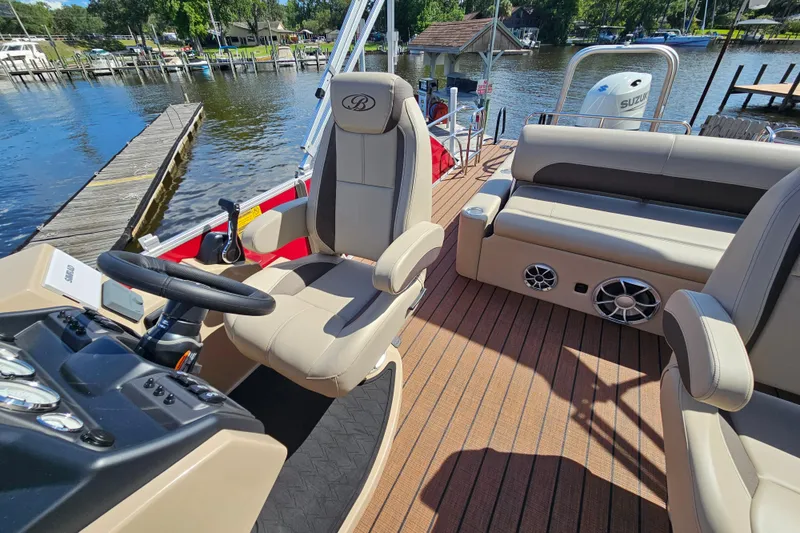 Slide: The Image of 2025 Bentley Pontoons Legacy 243 Swingback interior with helm, seating, and water view. - 18