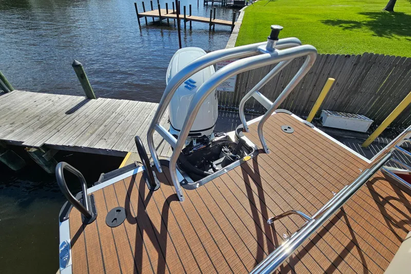 Slide: The Image of 2025 Bentley Pontoons Legacy 243 Swingback at dock, showcasing motor and deck. - 22