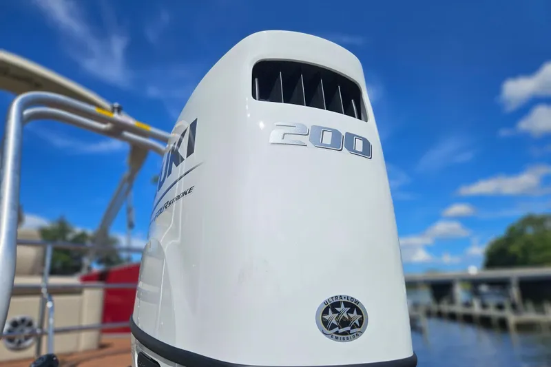Slide: The Image of Outboard motor on 2025 Bentley Pontoons Legacy 243 Swingback, under clear blue sky. - 4