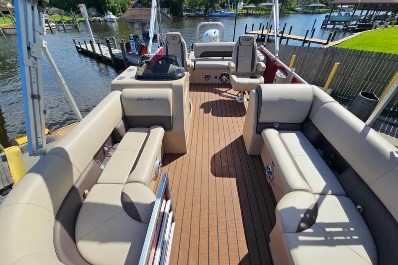 Slide: The Image of 2025 Bentley Pontoons Legacy 243 Swingback interior with luxurious seating and waterfront view. - 9