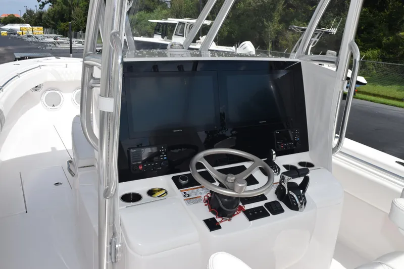 Slide: The Image of 2025 Contender 35 ST boat helm with dual screens and steering wheel. - 11