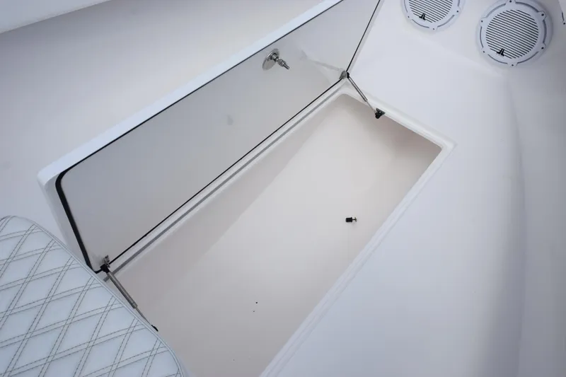 Slide: The Image of Open storage compartment on 2025 Contender 35 ST boat, featuring white interior and speakers. - 28