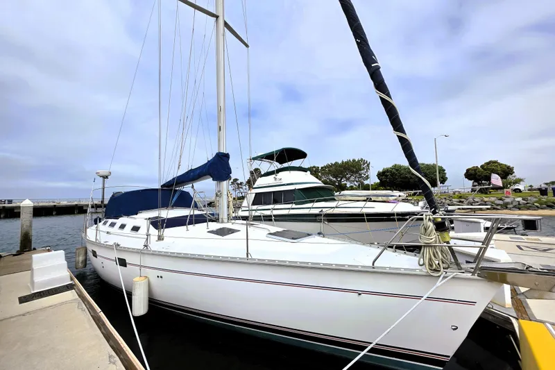The Image of Hunter 43 Legend sailboat, 1992 model, docked at marina under cloudy sky. - 0