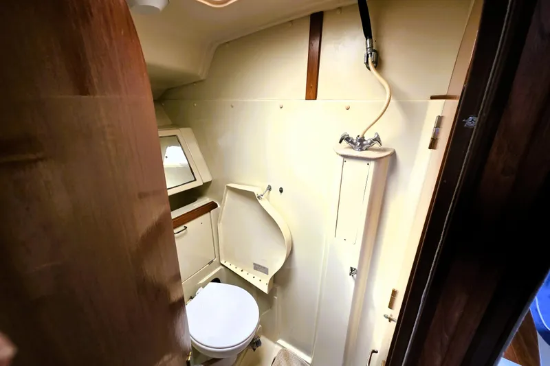 Slide: The Image of 1992 Hunter 43 Legend yacht bathroom with toilet, shower, and mirror. - 14