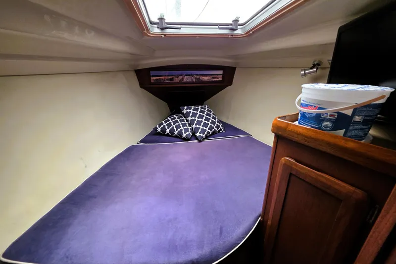 Slide: The Image of Cozy cabin interior of 1992 Hunter 43 Legend sailboat with purple bedding and decorative pillows. - 15
