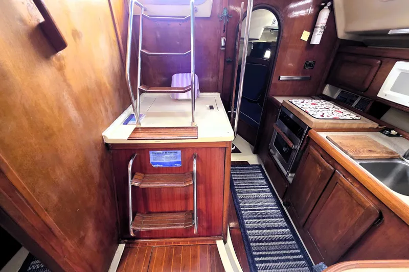 Slide: The Image of Interior of 1992 Hunter 43 Legend sailboat with wooden cabinetry and compact kitchen area. - 18