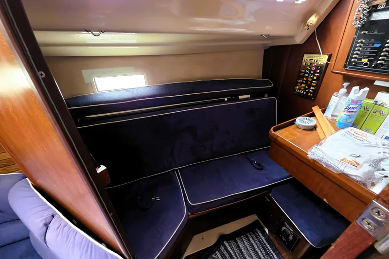 Slide: The Image of Cozy interior of 1992 Hunter 43 Legend sailboat with blue seating and wooden accents. - 2