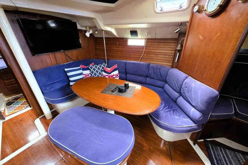 Slide: The Image of Interior of 1992 Hunter 43 Legend yacht with blue seating and wooden table. - 24