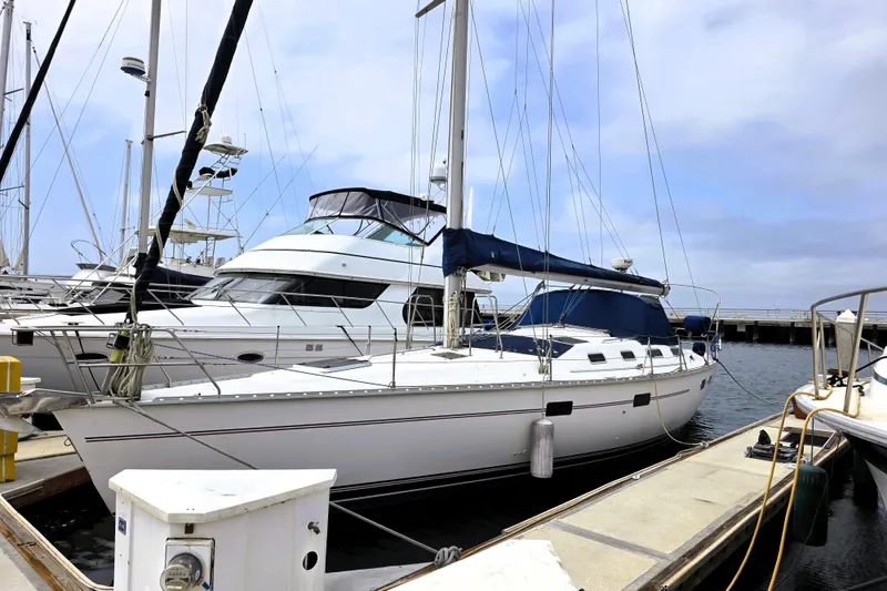 Slide: The Image of Sailboat Hunter 43 Legend 1992 docked at marina under cloudy sky. - 6
