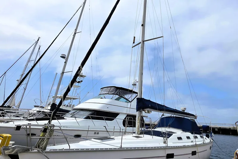 Slide: The Image of Hunter 43 Legend sailboat from 1992 docked at a marina under a cloudy sky. - 7