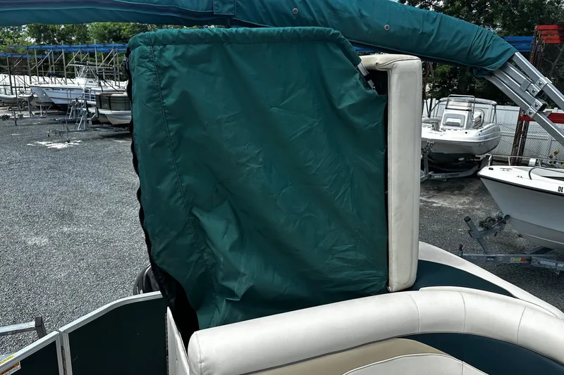 Slide: The Image of 2016 Godfrey Sweetwater 2086 Pontoon with green cover, parked among other boats. - 11