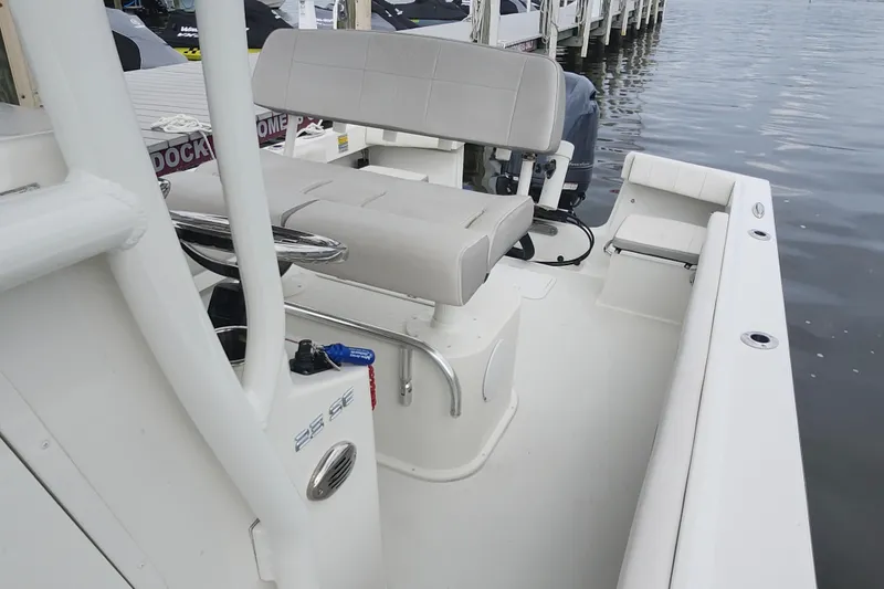 Slide: The Image of 2020 Parker 2300 Special Edition boat interior with seating and steering, docked by the water. - 17