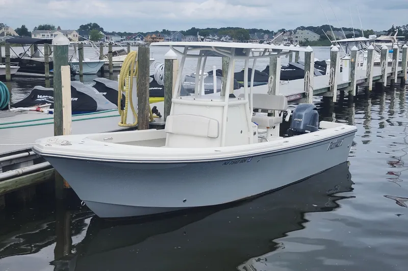 Slide: The Image of 2020 Parker 2300 Special Edition boat docked at a marina, calm water, overcast sky. - 6