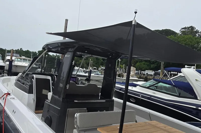 Slide: The Image of 2025 Schaefer V33 boat with canopy, docked at marina with other boats. - 6