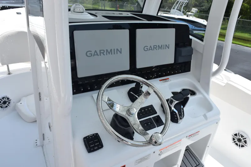 Slide: The Image of 2026 Sea Hunt Ultra 275 SE boat dashboard with Garmin displays and steering wheel. - 12