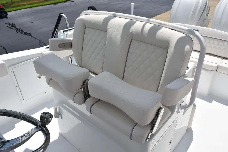 Slide: The Image of Luxury seating on 2026 Sea Hunt Ultra 275 SE boat, featuring cushioned armrests and steering wheel. - 13