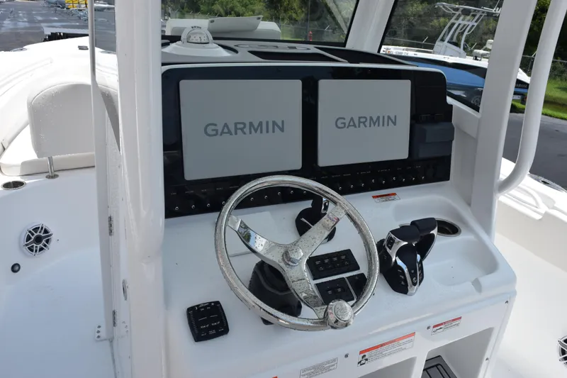 Slide: The Image of 2026 Sea Hunt Ultra 275 SE boat dashboard with dual Garmin displays and steering wheel. - 16