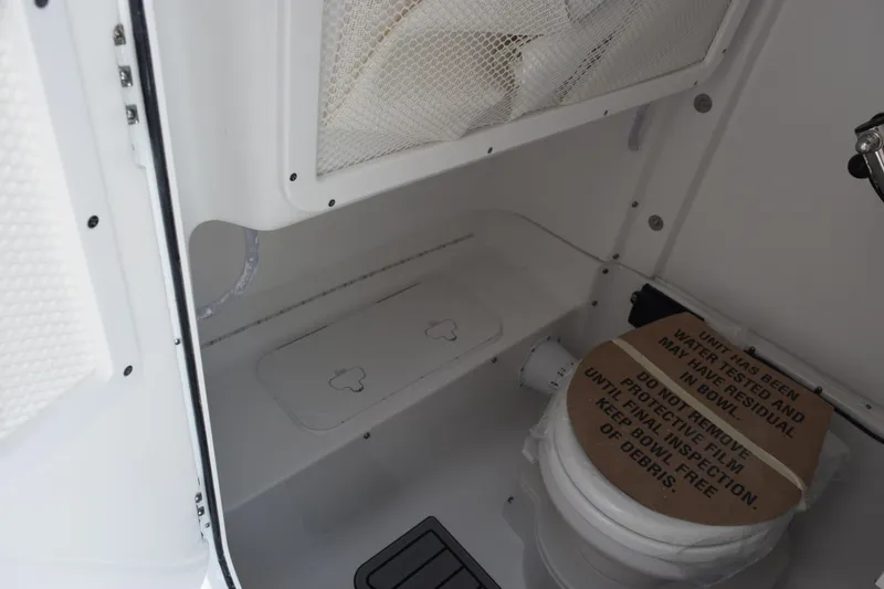 Slide: The Image of Interior of 2026 Sea Hunt Ultra 275 SE boat bathroom with toilet and storage. - 23