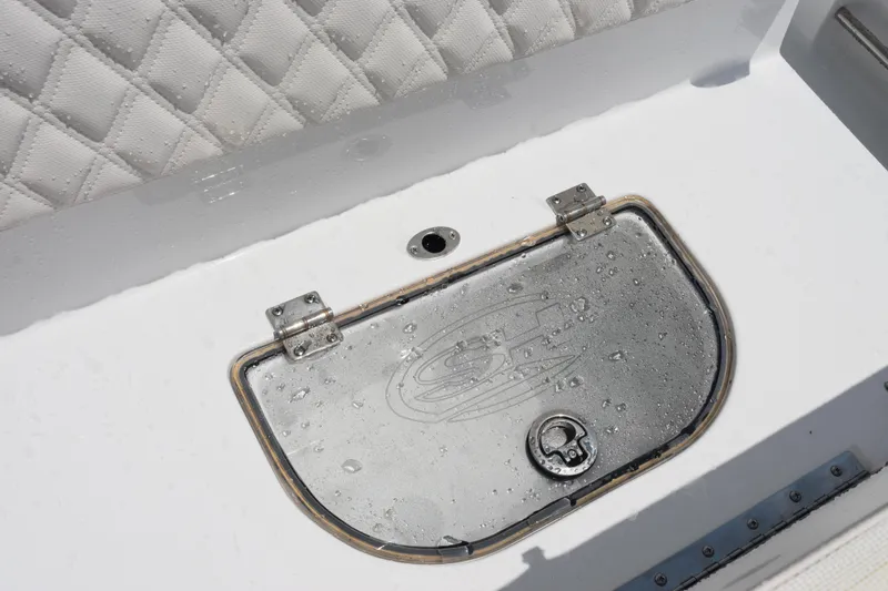 Slide: The Image of Hinged compartment on 2026 Sea Hunt Ultra 275 SE boat with water droplets. - 30