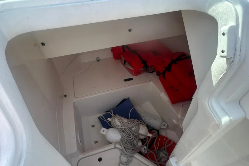 Slide: The Image of Storage compartment of 2023 Sea Ray SDX 250 Outboard with life jackets and ropes. - 12