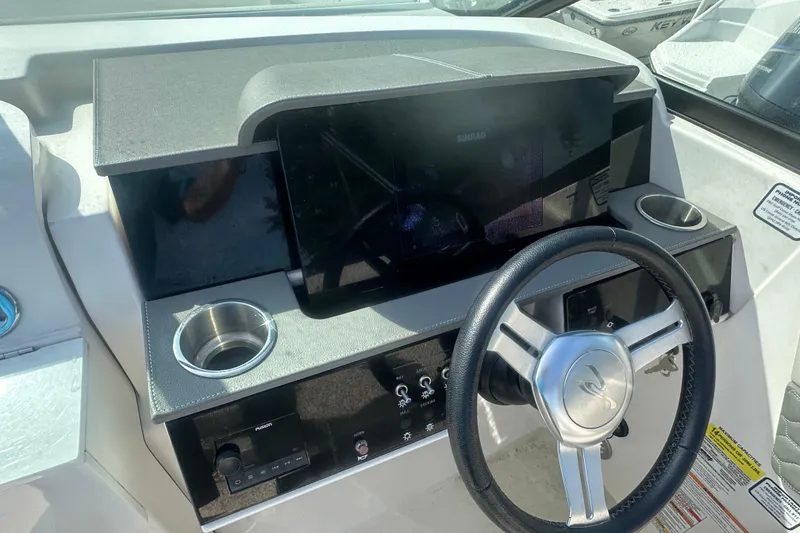 Slide: The Image of 2023 Sea Ray SDX 250 Outboard dashboard with steering wheel and control panel. - 13