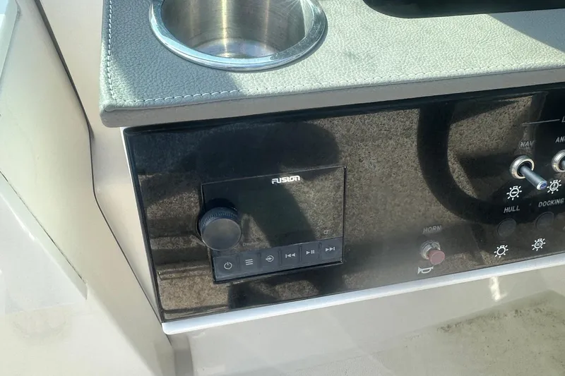 Slide: The Image of 2023 Sea Ray SDX 250 Outboard dashboard with Fusion audio controls and cup holder. - 14