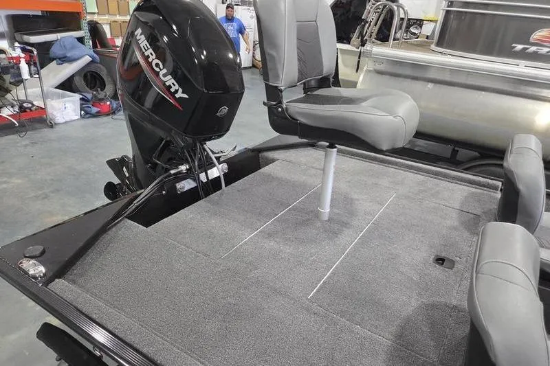 Slide: The Image of 2026 Tracker BT CLASSIC XL boat with Mercury engine and swivel seat in a garage. - 8