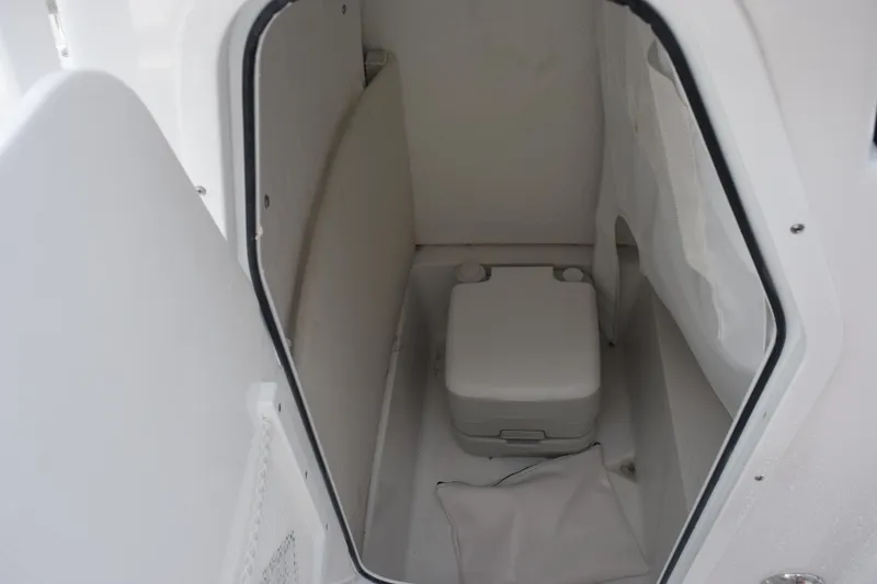Slide: The Image of 2026 Sea Hunt Ultra 219 boat interior with compact marine toilet. - 12