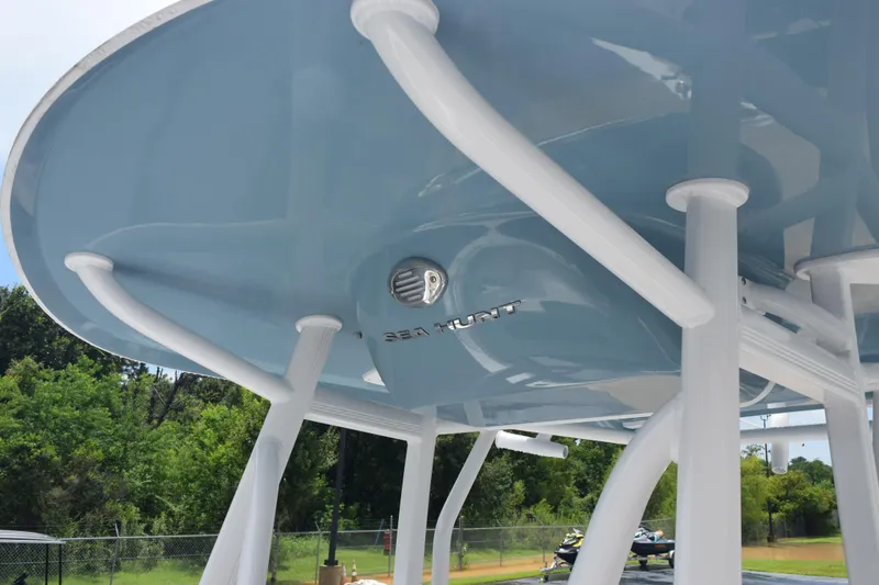 Slide: The Image of 2026 Sea Hunt Ultra 219 boat with sleek blue and white design, viewed from below. - 15
